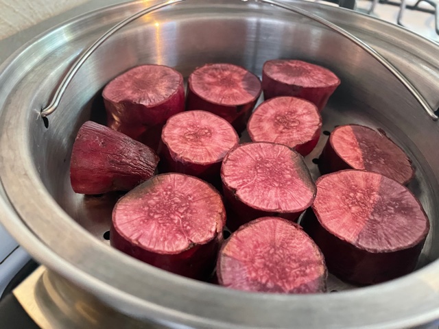 Olla de vapor con trozos de batata morada cocinándose